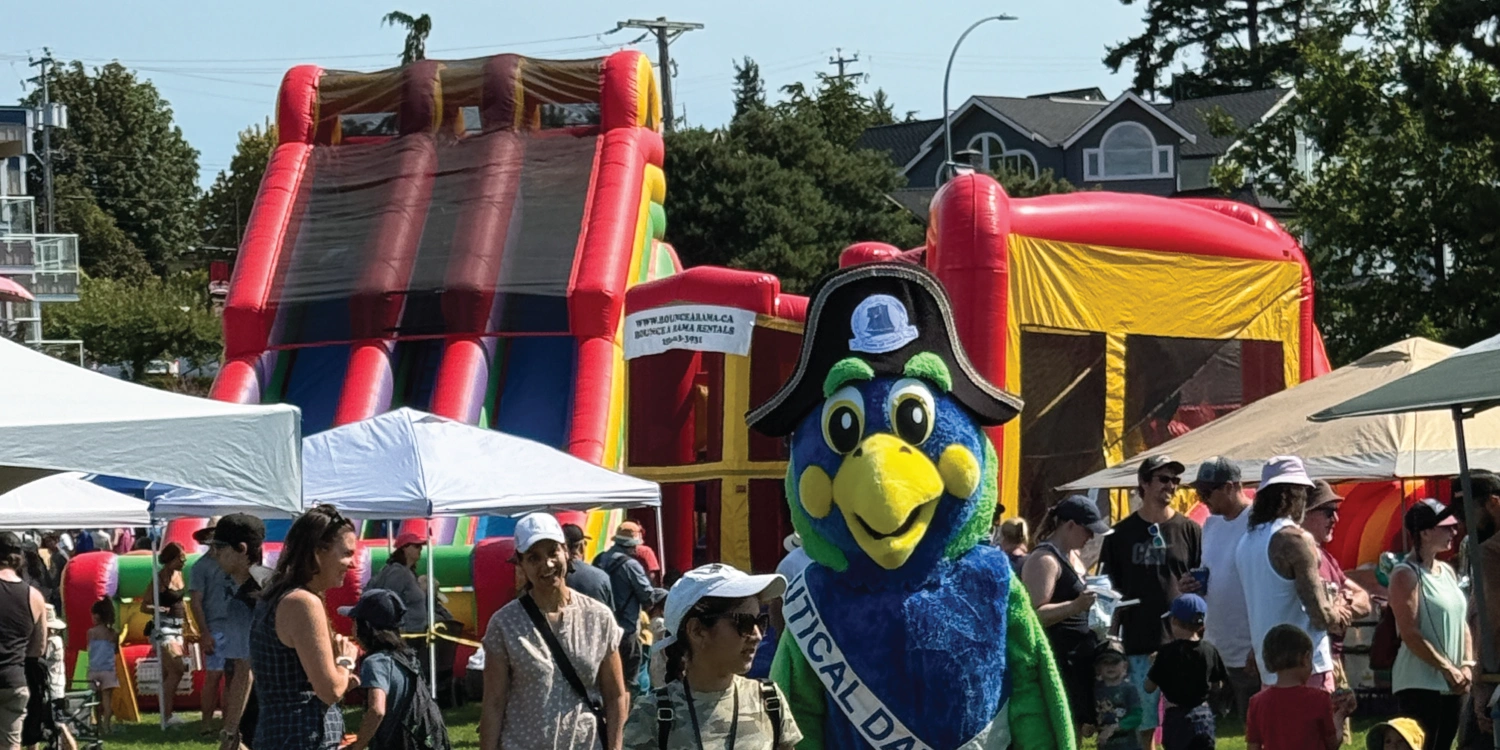 Comox Nautical Days The Nautical Days Mascot - a pirate parrot stands infrom of a crowd at Nautical days in Comox