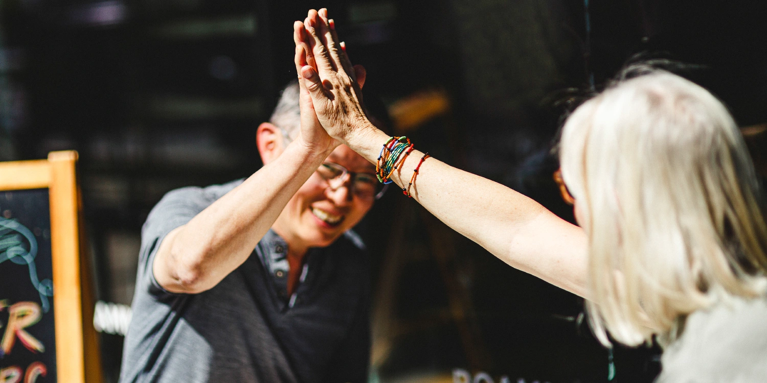 two people high fiving after completing the drawn together exercise