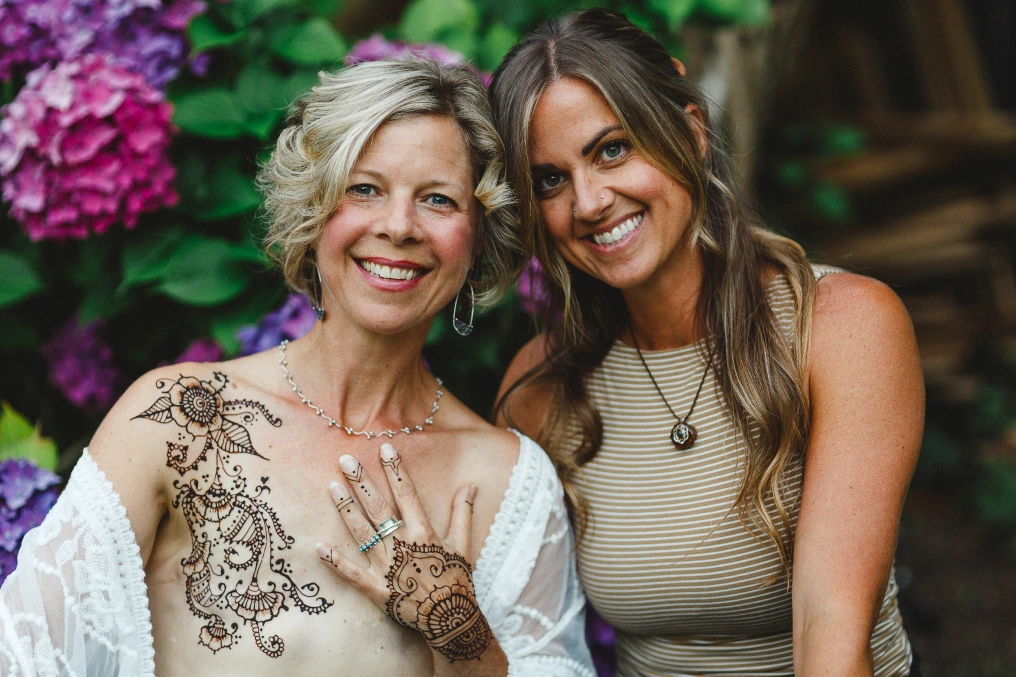 Healing through art Breast cancer survivor Shannon with artist after healing through art session with henna body art