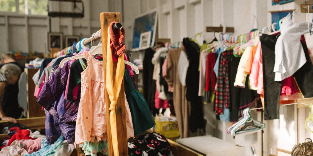Colorful children's clothing displayed on wooden racks at the Hornby Island Free Store