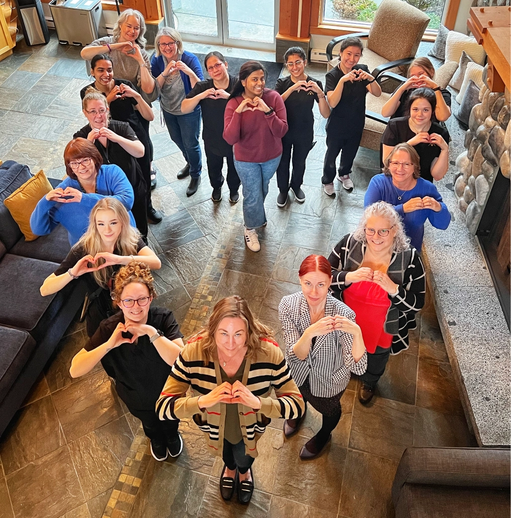 Old House Hotel and Ohspa team members making heart hand gestures in hotel lobby