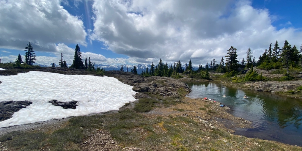Comox District Mountaineering Club celebrates 100 years with its 2028 Hiking Challenge Alpine lake with lingering snow patches in Strathcona Provincial Park, popular destination for Comox Valley hiking enthusiasts
