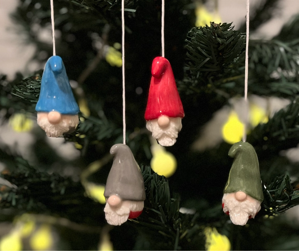 Colorful handmade ceramic gnome ornaments hanging on Christmas tree, created by Campbell River artists