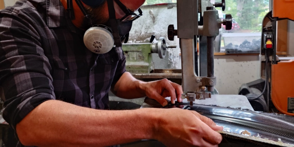 Craftsman working on carbon fiber kayak paddle at Nimbus Paddles workshop on Quadra Island