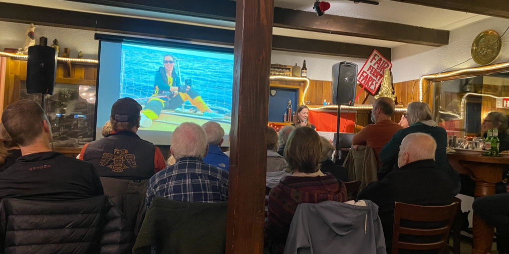 Community gathering at Heriot Bay pub watching University of Quadra presentation