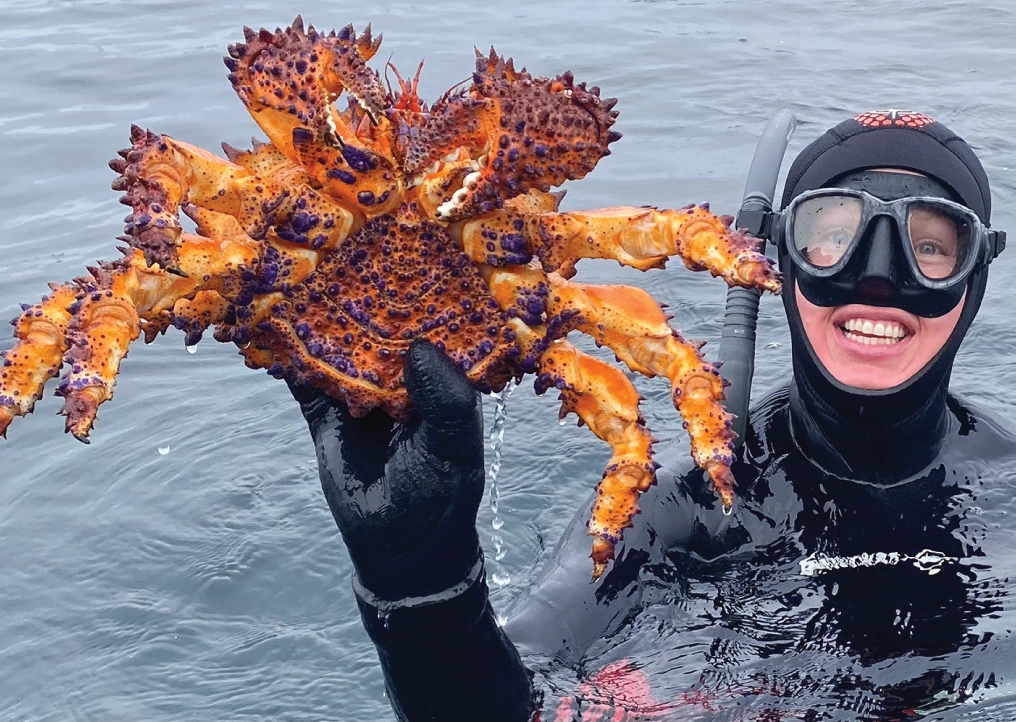 freediver holds up a big crab