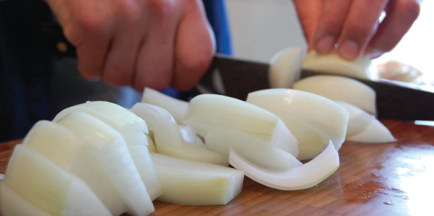 close up of hands chopping onions to make broth