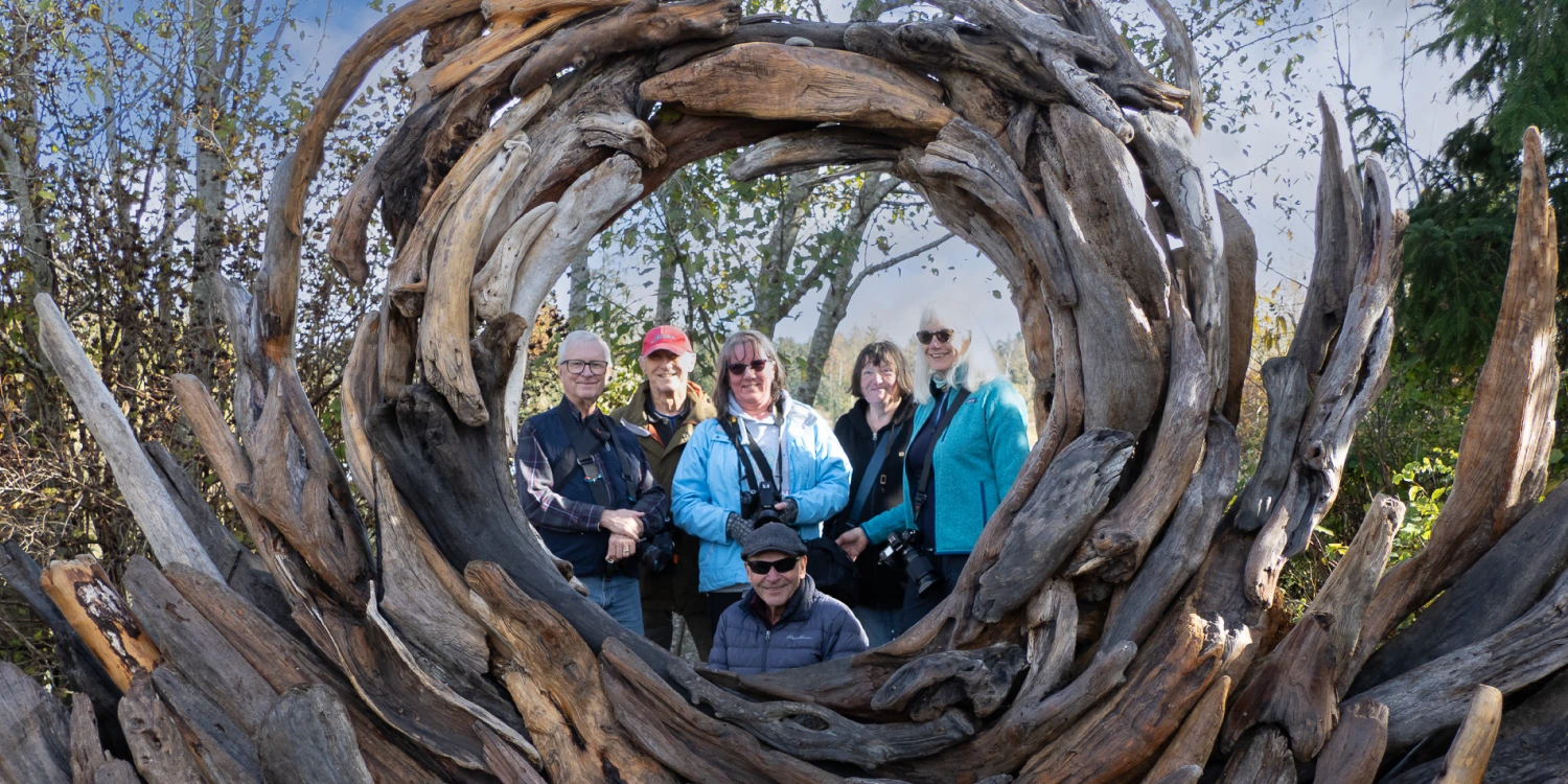CVPS group photo, standing in the centre of a driftwood sculpture