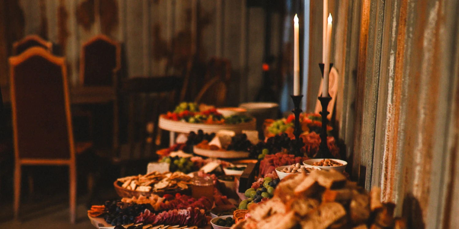 Farmer's potluck table full of food under candle light