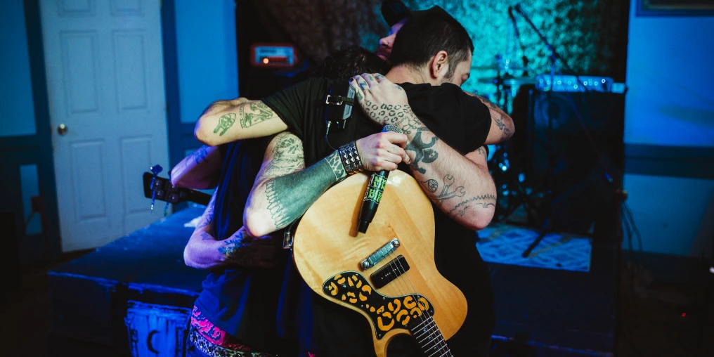 Members of Mean Bikini embrace on stage at a Cumberland BC punk show