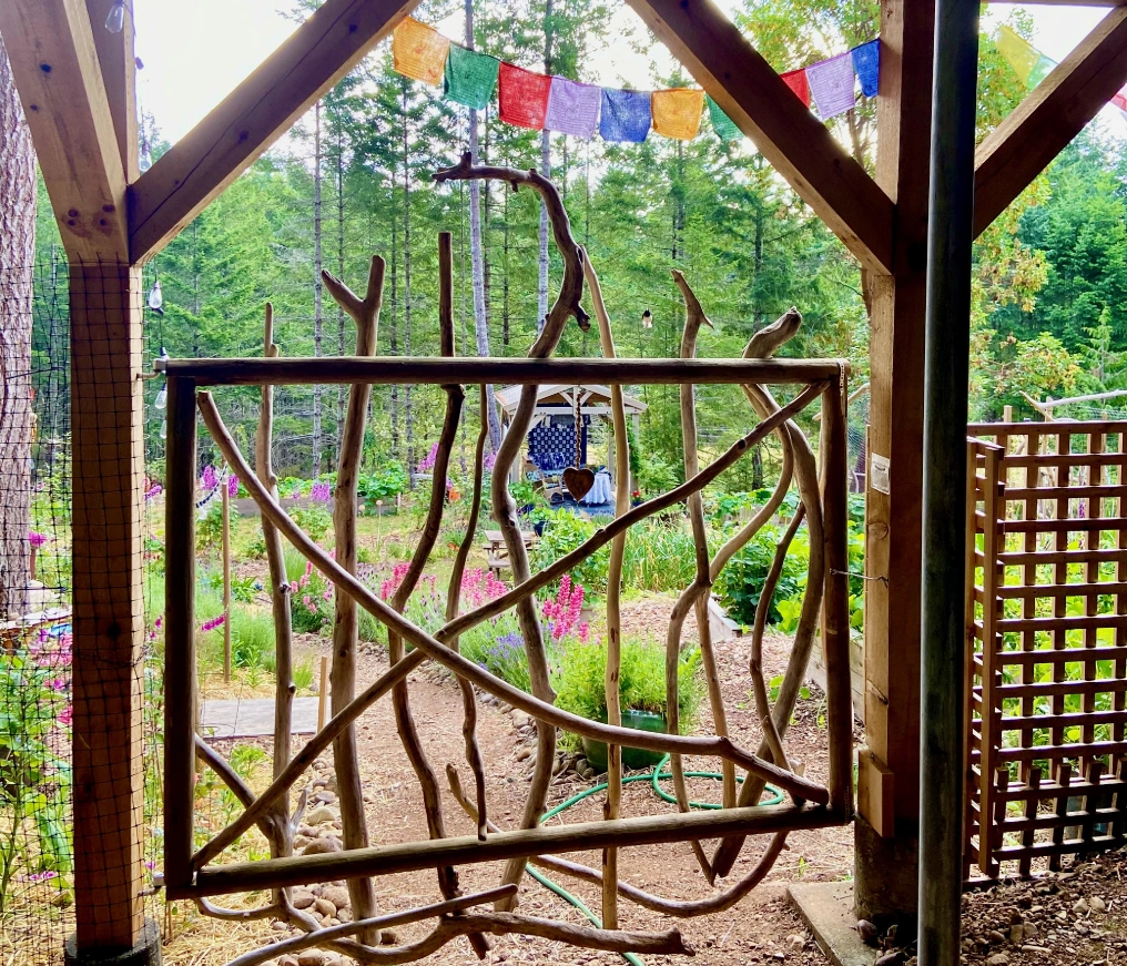 Handcrafted driftwood gate framing a garden view at the Denman Island Home and Garden Tour