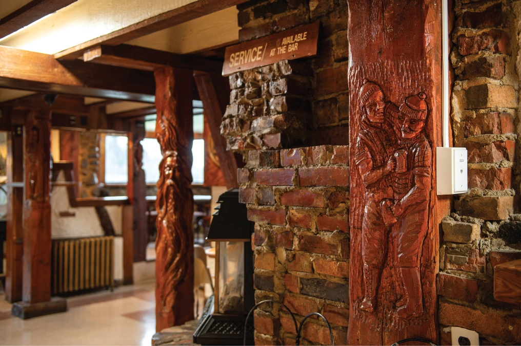 Hand-carved wooden pillars and stone walls inside The Goose and Gander pub in Campbell River