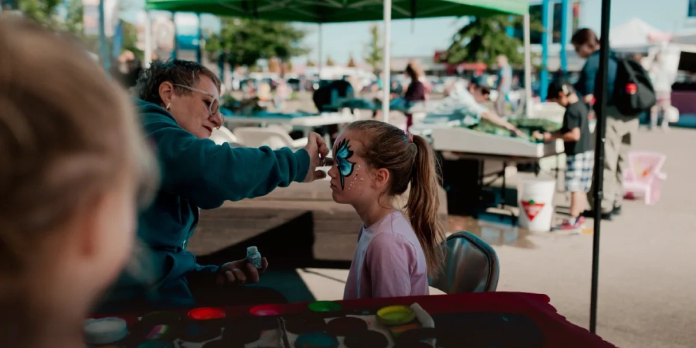 A child gets a butterfly face painting at the Campbell River Farmers Market