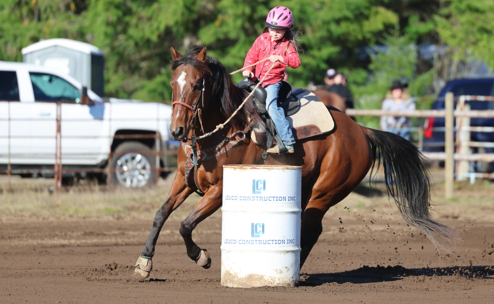 Young rider rounding a barrel at Innes Arena