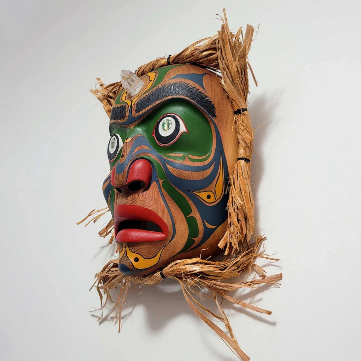 james-kwaksistala-‘na̲muk̓wala-speakersmask James Kwaksistala's ‘na̲muk̓wala Speaker mask made from, red cedar, cedar bark, acrylic paint, abalone and glass crystal