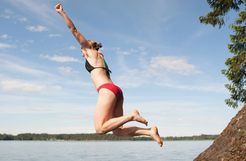Sunscreen, summer, and the Comox Lake watershed Swimmer leaping off a rock into Comox Lake on a summer afternoon