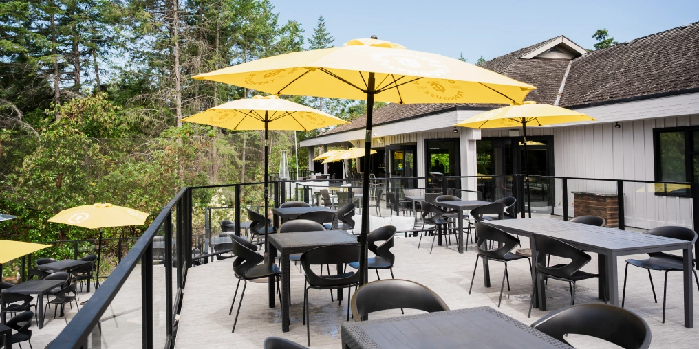 How Moments Hospitality Group creates a special moment in time for their guests Outdoor patio with yellow umbrellas at Greenview Taphouse on Fairwinds Golf Course