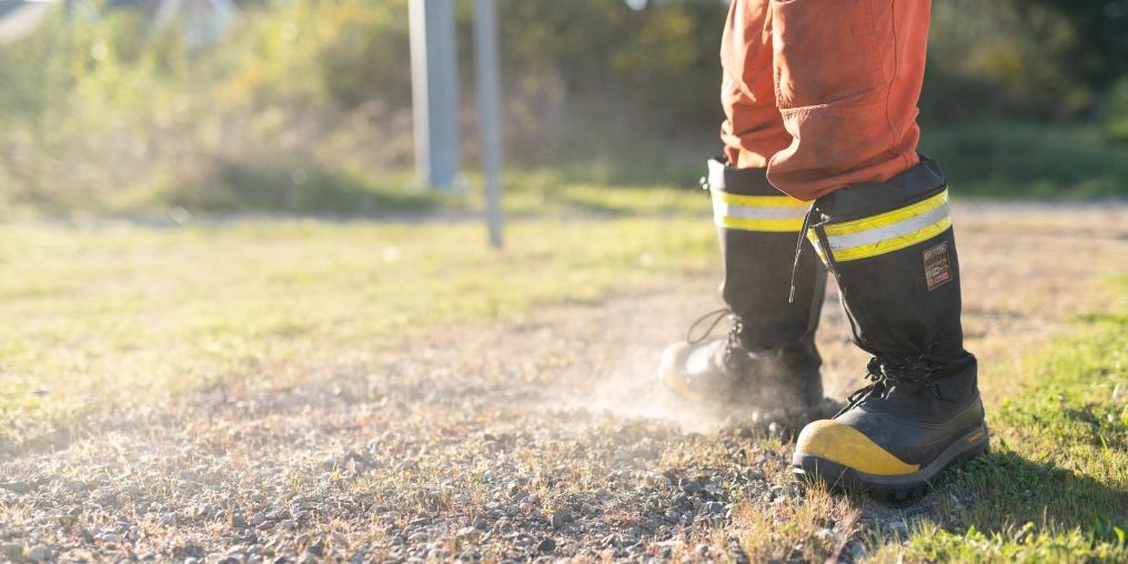 the gift of purpose Close-up of work boots kicking up dust on a gravel trail during a cleanup