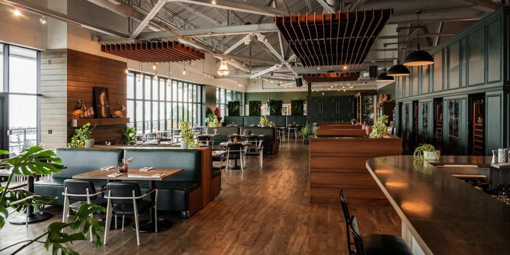 How Moments Hospitality Group creates a special moment in time for their guests Wood-beamed dining room and bar with wine cave walkway at Nanoose Bay Cafe