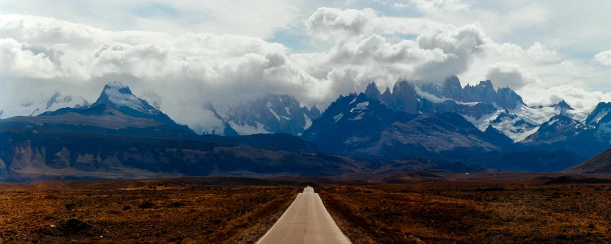 eric-overhoff-el-chalten A road leading straight toward the jagged peaks near El Chaltén, Argentina, under heavy clouds