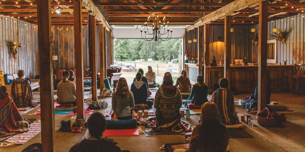 Agritourism - A key to farm viability on Vancouver Island A group sits on mats during an indoor wellness retreat session in a rustic farm barn