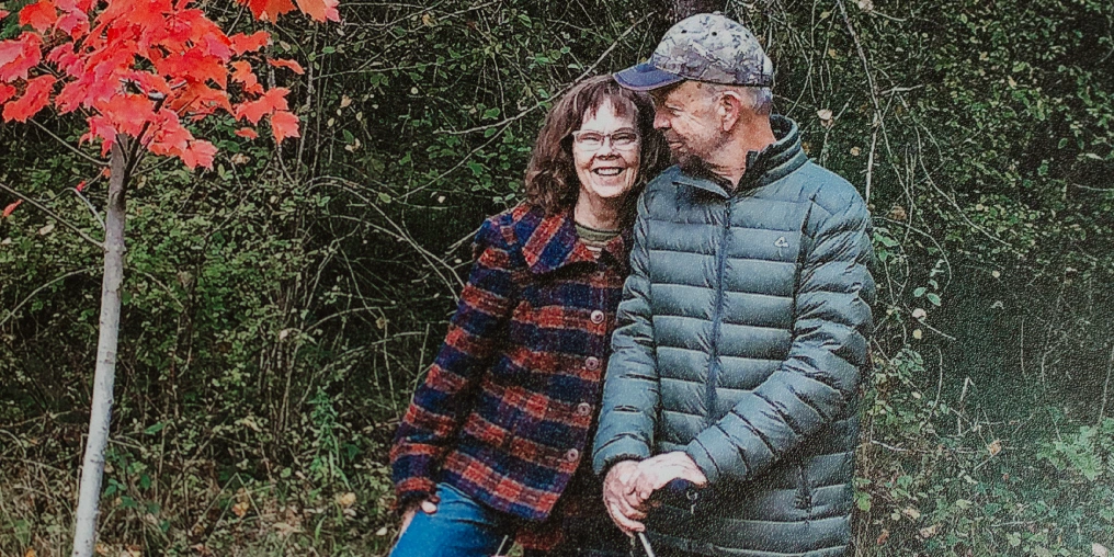 Portrait of Harold and Judy Macy next to a small maple tree.