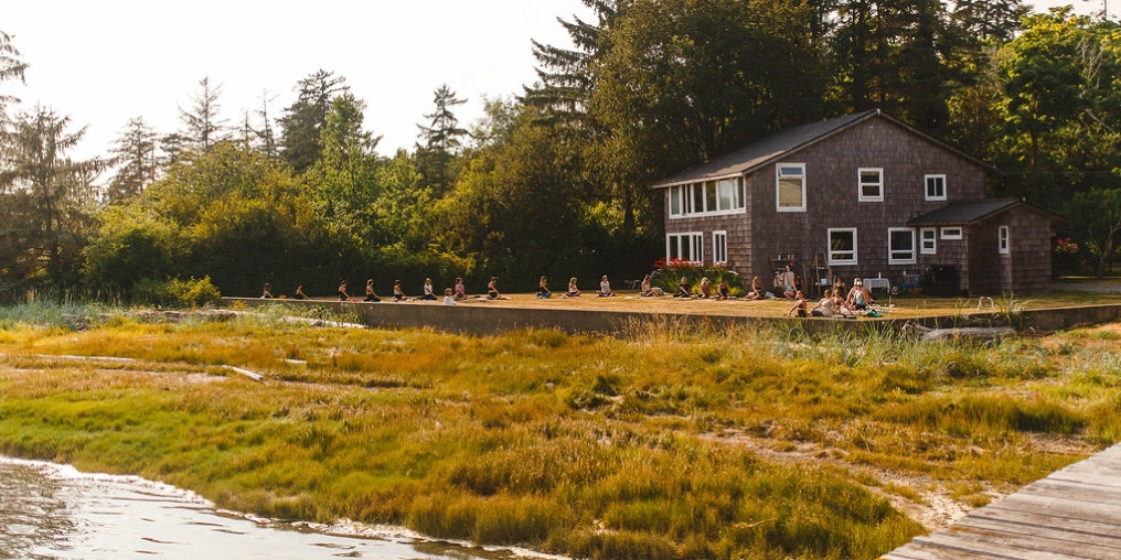 beside a cedar-shingled house in Royston, with marsh grass and a dock in the foreground